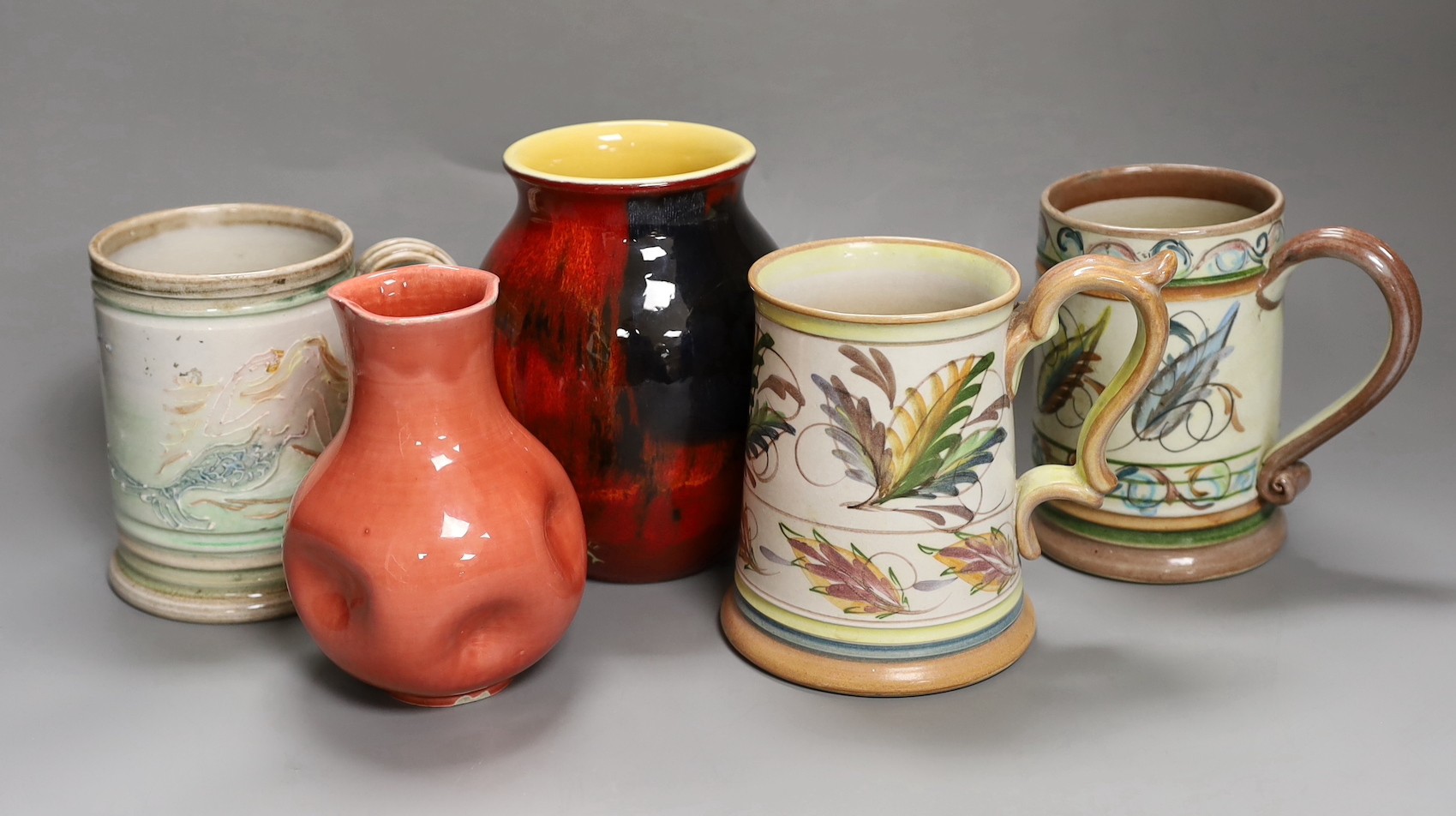 Three Glyn College jugs, a flambé Poole vase and a Burmantoft ‘White’ dimpled vase no. 989, tallest 16.5cm